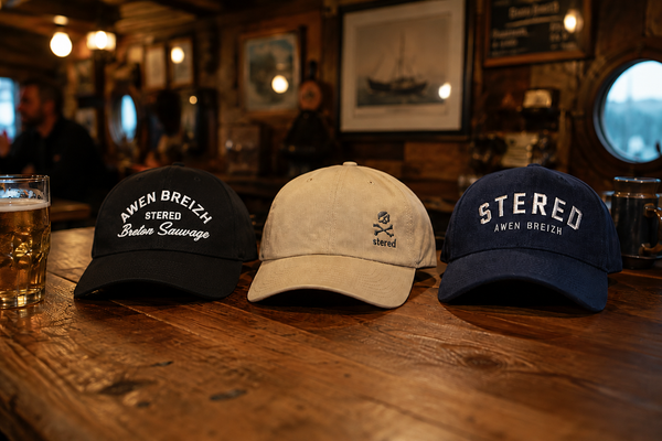 Trois casquettes STERED présentées sur une table dans un bar maritime breton
